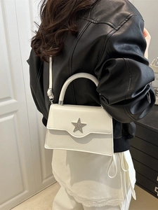 Weiße minimalistische Umhängetasche mit silberner Sternschnalle an einem Frauenmodel