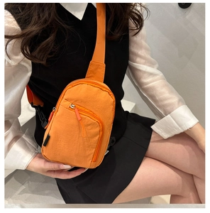Vue macro d'un sac de poitrine en nylon orange étanche avec des poches zippées