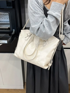Minimalist off-white oversized faux leather tote bag with silver star metal accent