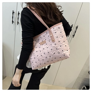 Dettaglio della borsa tote rosa a pois con fiocchi neri e sottili spalline in pelle