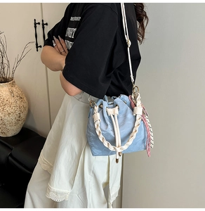 Light blue bucket bag with pleated leather texture and pink checkered scarf detail