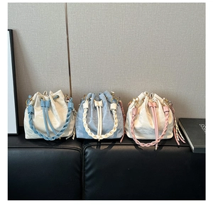 Detail view of colorful braided straps and drawstring closure on bucket shoulder bags