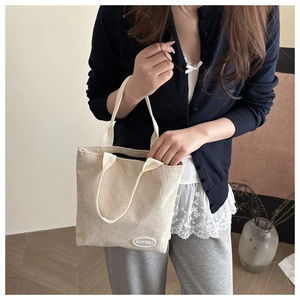 Detail view of cream corduroy tote bag showing ribbed texture and FANYISSA label