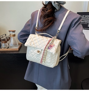 Detailed back view of white quilted PU leather backpack with gold clasp and tassel charm