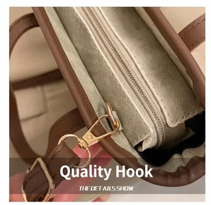 Detailansicht der braunen Ledertasche mit goldenem Metallhaken und feiner Nahtführung