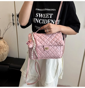 Detail of pink quilted synthetic leather backpack with golden twist lock and charm