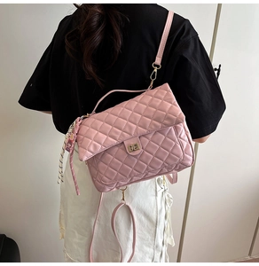Pink quilted crossbody bag detail with golden twist lock and cartoon charm pendant