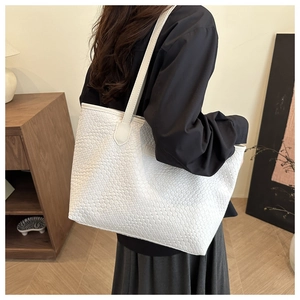 Detailed macro view of the woven leather texture on this white large capacity tote bag