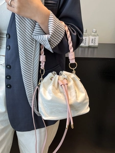 Elegant pearl white satin bucket bag with pink braided handle and adjustable shoulder strap