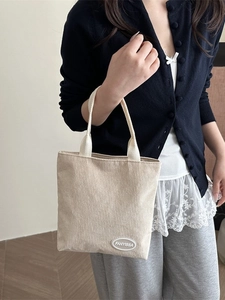 Beige corduroy tote bag for women with minimalist brand patch and top handles