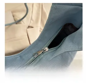 Close-up of the smooth metal zipper on this light blue canvas tote bag for women