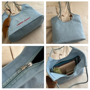 Detail view of light blue canvas tote with embroidery and spacious interior capacity