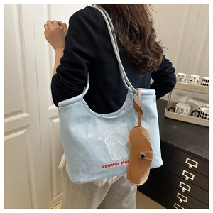 Detail of light blue denim tote bag with cute dog embroidery and lace trim design
