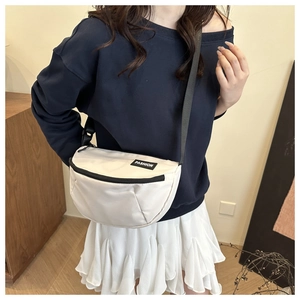 Détail du sac bandoulière en nylon blanc avec étiquette FASHION et sangle noire réglable