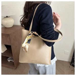 Side view of a beige matte leather tote bag with stylish printed scarf decoration
