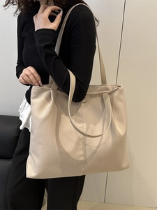 Minimalist beige canvas tote bag with long handles for shoulder or hand carry style