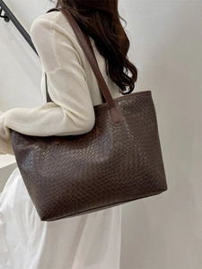 Large dark brown woven tote bag for women shown from a side view for daily commuting