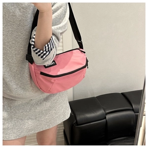 Mirror selfie showing the pink water-resistant crossbody bag on a model with a black strap
