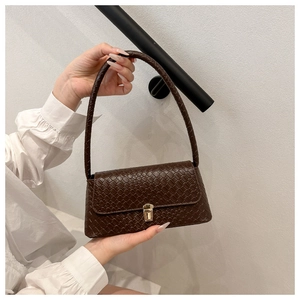 Detail of dark brown woven baguette bag with vintage gold metallic buckle for women
