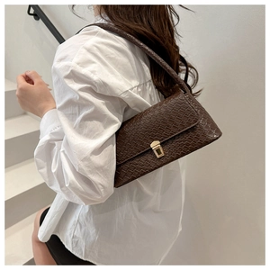 Detail of dark brown croc-effect shoulder bag with golden metallic buckle closure