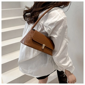 Détail de la texture tressée marron sur le sac vintage avec boucle en métal doré chic