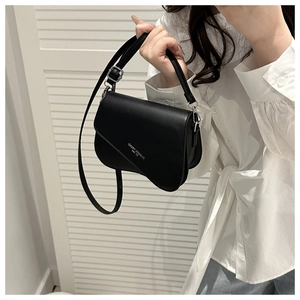 Detail of black saddle bag with adjustable strap and Fashion Trend 1980 white lettering