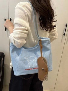 Light blue canvas tote bag with cartoon dog embroidery and brown leather glasses pouch