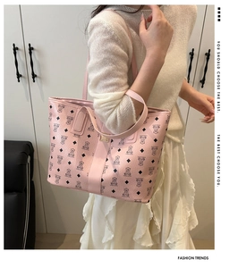 Detailed view of pink leather tote bag with cartoon bear pattern on white outfit