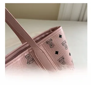 Close-up of pink tote bag showing lychee leather texture and precise edge stitching