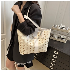 Détail d'un sac cabas beige avec motifs d'ours et poignées en cuir blanc