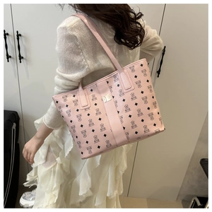 Gros plan détaillé d'un sac cabas rose en cuir avec imprimé ours et longues poignées