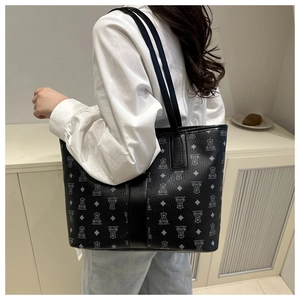 Macro shot of stylish black tote bag with bear print pattern and slim shoulder straps