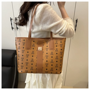 Detail view of large brown faux leather tote bag with bear print and long shoulder strap