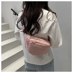 Sac de poitrine rose rayé avec bandoulière réglable porté par un mannequin en escalier