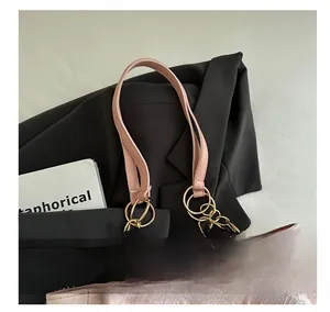 Close-up of pink embroidered floral tote bag with leather handle and gold chain detail