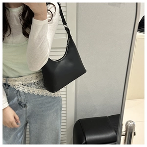 Mirror selfie showing the black hobo shoulder bag size and fit on a person