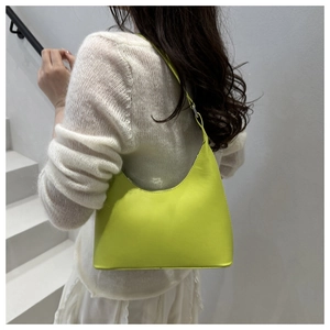 Neon green half-moon underarm bag with smooth leather finish worn by a model