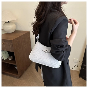 Detail of woven white shoulder bag featuring a silver metallic star and elegant texture