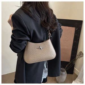 Detail of coffee-colored faux crocodile texture underarm bag with silver star buckle