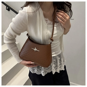 Close-up of brown crocodile embossed hobo bag with a silver star and knotted strap detail