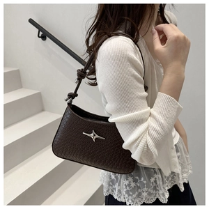 Détail du sac sous l'aisselle tissé marron foncé avec étoile argentée et nœud