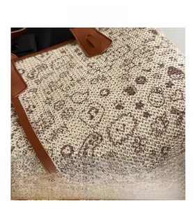 Detailed view of woven tote bag featuring vintage paisley patterns and leather handles