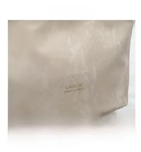 Close-up of marble texture bucket bag with gold logo lettering on premium faux leather