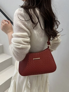 Burgunderrote Leder-Achseltasche mit Flechtmuster und Goldschnalle am Model