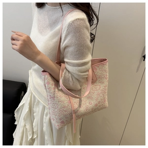 Detail der gewebten Tragetasche in Rosa und Beige mit Lederriemen am Modell