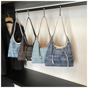 Detail of denim bow tote bags in four shades with blue and white beaded drawstrings