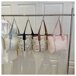 Detail of woven tote bags with colorful cartoon graffiti and faux leather handles