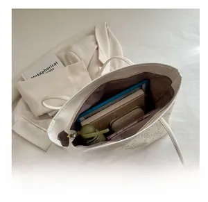 Interior view of white tote bag showing large capacity for laptop and daily items