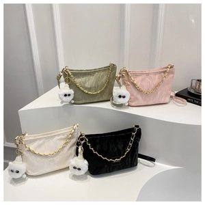 Close-up of four pleated shoulder bags in green, pink, white, and black with chains