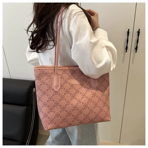 Detail of pink floral tote bag with cherry blossom print worn on shoulder by model